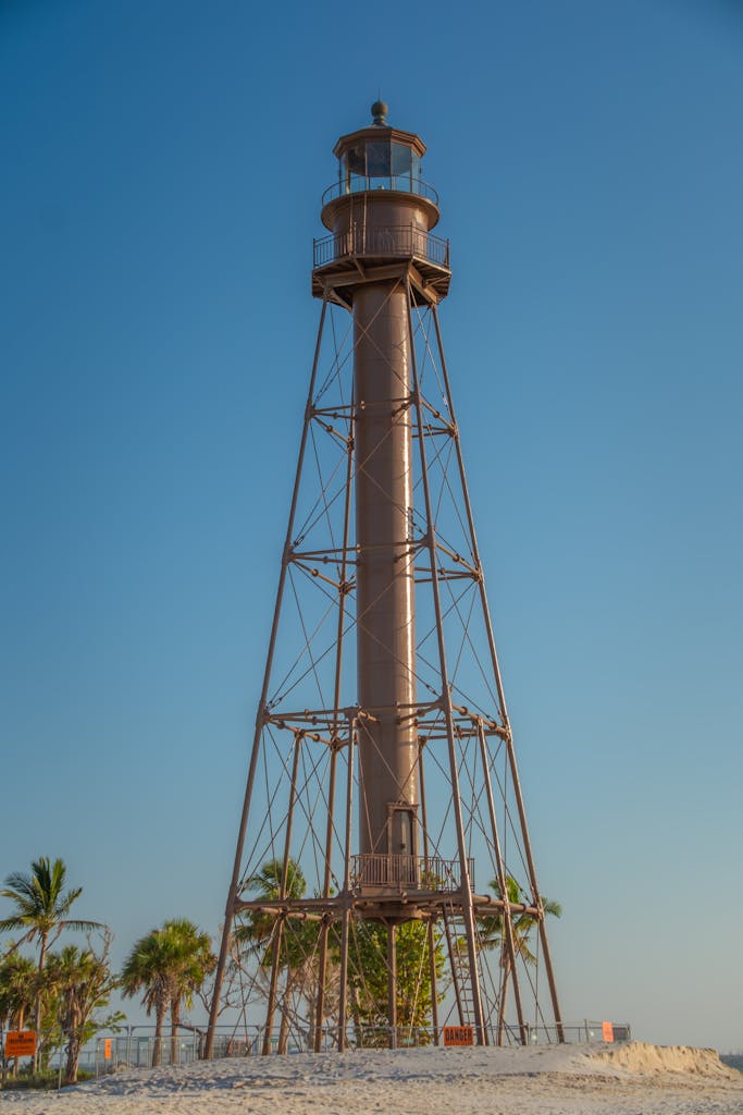 Beautiful lighthouse on a sunny beach with palm trees, perfect for travel and maritime themes.